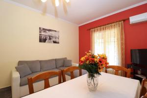 卡諾尼的住宿－A Nice Apartment- Corfu Town, Kanoni，客厅配有沙发和鲜花桌