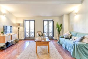 uma sala de estar com um sofá azul e uma mesa em Cocon Carcassonnais - Parking Gratuit - WIFI - Netflix - Proche Cité - Tout Equipée em Carcassonne