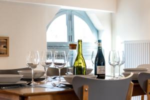 a table with wine bottles and glasses on it at L'Escapade - Parking Gratuit - WIFI - Climatisation - Proche Cité - Tout Equipée in Carcassonne +29 photos