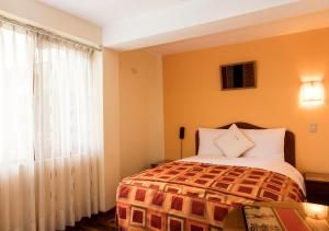 a bedroom with a bed and a window at Laramani Hotel Boutique in Cusco