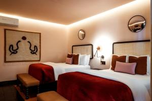 a hotel room with two beds with red sheets at Casa Hoyos - Hotel Boutique in San Miguel de Allende
