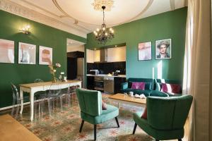 a living room with green walls and a table and chairs at Central Suites Barcelona in Barcelona