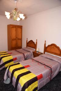 1 dormitorio con 2 camas y mantas a rayas en Apartamentos Doña Carmen, en Los Silos