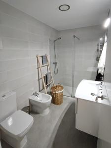 a white bathroom with a toilet and a sink at ARTE Playa la Caleta Grupo AC Gestion in Cádiz