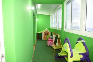 ein grünes Zimmer mit einem Tisch und einem Spielzeughaus in der Unterkunft Apartamentos Doña Carmen in Los Silos