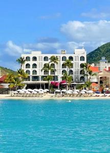 a hotel on the beach with the water in front at Holland House Beach Hotel in Philipsburg