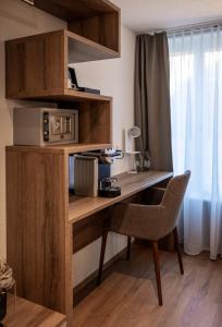 a desk with a microwave and a chair in a room at Hotel & Restaurant Bären in Niederbipp