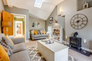a living room with a couch and a stove at Broadrock Accommodation - Clock Cottage in Chepstow