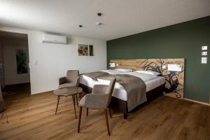 a bedroom with a large bed and two chairs at Hotel & Restaurant Bären in Niederbipp