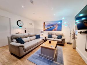 a living room with a couch and a table at Bournemouth Luxury Apartment in Bournemouth
