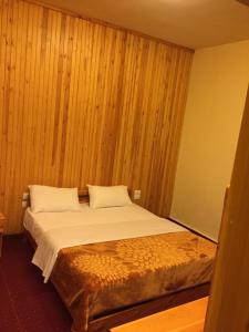 a large bed in a room with wooden walls at Tamerland-faraya in Fārayyā