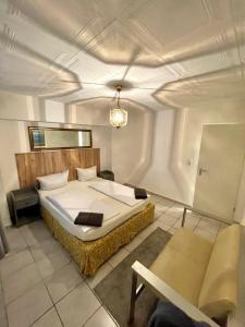 奧芬巴赫的住宿－內洛酒店，一间卧室配有一张大床和一把椅子