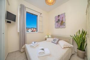 a bedroom with a bed with towels and a window at Flowers in the city - Elegant Home in Argostoli in Argostoli