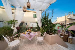 a patio with a table and chairs in a yard at Flowers in the city - Elegant Home in Argostoli in Argostoli