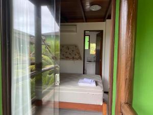 a small room with a small bed and a window at BANGALÔ - Varandas do Mar - Praia de Itacimirim in Camaçari +13 photos