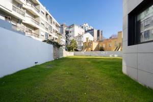 a grassy yard in the middle of a building at Habitatio - Bom Sucesso in Porto