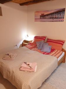 ザラツァニにあるKis Ház Apartmanのベッドルーム1室(ベッド1台、タオル2枚付)