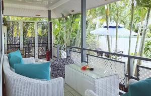eine Veranda mit Stühlen, einem Tisch und einem Sonnenschirm in der Unterkunft Lagoon Dream in Moorea