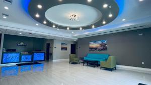 a waiting room with blue chairs and a ceiling at Days Inn & Suites by Wyndham Greater Tomball in Tomball