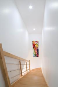 a staircase in a white room with a painting on the wall at Le temps d'une pause' 