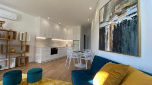 a living room with a blue couch and a kitchen at FERREIRA'S HOUSE Viana do Castelo in Viana do Castelo