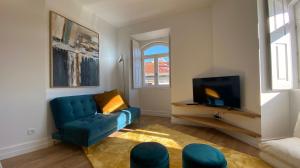 a living room with a blue couch and a tv at FERREIRA'S HOUSE Viana do Castelo in Viana do Castelo