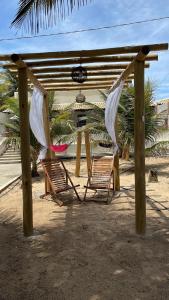 duas cadeiras debaixo de uma pérgula na praia em Casa de Praia - Aracaju - Jatobá em Barra dos Coqueiros