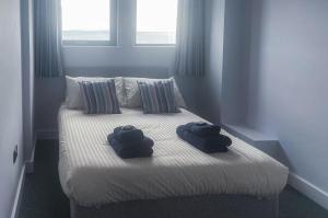 two towels sitting on a bed in a bedroom at No 2 Ocean Cabins - Saundersfoot Harbour - Saundersfoot in Saundersfoot