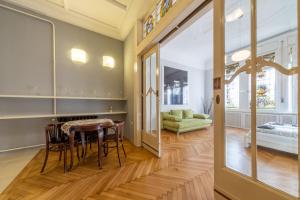 a dining room with a table and a green couch at Elisabeth Apartment on Váci Street in Budapest