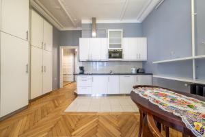 a kitchen with white cabinets and a wooden floor at Elisabeth Apartment on Váci Street in Budapest