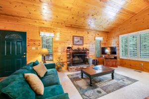 sala de estar con sofá verde y chimenea en Elk Horn Retreat, en Idyllwild