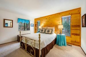 a bedroom with a bed and a wooden wall at Elk Horn Retreat in Idyllwild