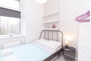 - une petite chambre avec un lit et une fenêtre dans l'établissement Sydonia Apartments - Unisławy, à Szczecin