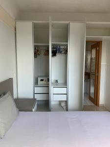 Un dormitorio con una gran cama blanca y espejos en Tropical Executive Hotel, en Manaus