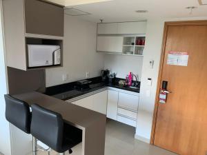 a small kitchen with white cabinets and a counter top at Tropical Executive Hotel in Manaus +3 photos