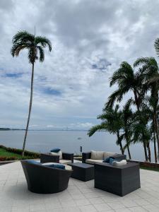 a patio with couches and palm trees next to the water at Tropical Executive Hotel in Manaus