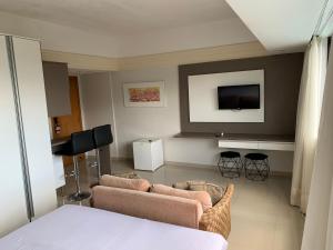 a living room with two couches and a tv at Tropical Executive Hotel in Manaus