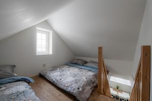 a attic bedroom with a bed and a window at Marcebila Abertamy in Abertamy