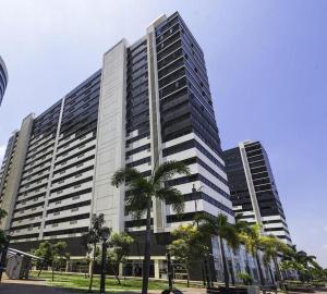 a large building with palm trees in front of it at Ecusuites Room 44 bellini Gye Santa Ana in Guayaquil