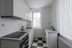 a kitchen with white cabinets and a checkered floor at Marcebila Abertamy in Abertamy
