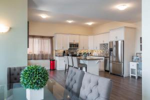 a kitchen and living room with a table and chairs at Oh What A View! - Lower Suite in Vernon
