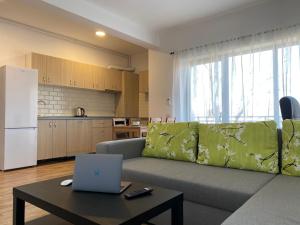 ein Wohnzimmer mit einem Sofa und einem Laptop auf dem Tisch in der Unterkunft GLAM APARTMENTS Lipatti near Iulius Mall in Timişoara