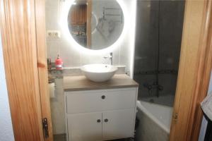 een badkamer met een wastafel, een spiegel en een bad bij CHECK-IN CASAS Luana in Benasque