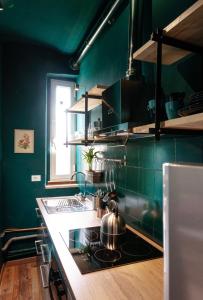 eine Küche mit grünen Wänden und einem Herd Top-Backofen in der Unterkunft I Ponti Canal House in Sanzinnen