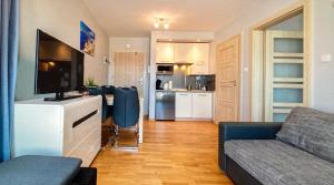 a small living room with a couch and a kitchen at Apartament Atlantycki in Jastrzębia Góra