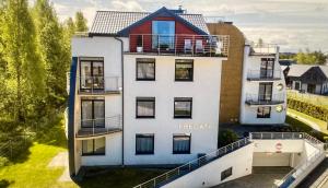 biały dom z czerwonym dachem w obiekcie Apartament Atlantycki w Jastrzębiej Górze