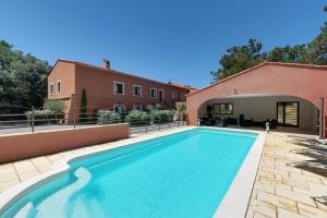 a swimming pool in the backyard of a house at Hotel du Mas in Vinassan