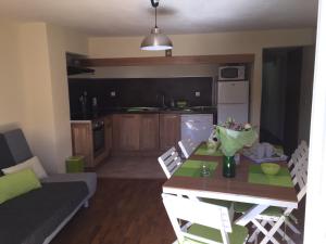 a kitchen and living room with a table and a couch at Le Cocovert du Verdon in Riez
