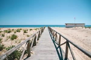 a wooden boardwalk leading to the beach at Hotel Avenida Playa in Zahara de los Atunes