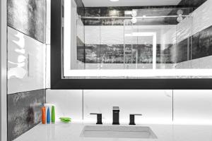 a bathroom with a sink with the word h on it at Casa Azul Hotel Blu-UBS Arena in Queens +20 photos